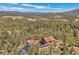 Breathtaking aerial view of a stunning home nestled among lush trees with mountain views at 10786 Marclif Rd, Conifer, CO 80433