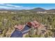 An aerial view of a beautiful home surrounded by a lush forest with mountain views at 10786 Marclif Rd, Conifer, CO 80433