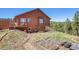 Backyard with garden beds and deck outside a home with brown siding at 10786 Marclif Rd, Conifer, CO 80433