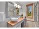 Well-lit bathroom featuring a window view, wood countertop, vessel sink and a glass shower at 10786 Marclif Rd, Conifer, CO 80433