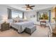 Cozy bedroom featuring a ceiling fan, two windows with curtains, and comfortable seating at 10786 Marclif Rd, Conifer, CO 80433