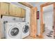 Convenient laundry room with washer, dryer, cabinets, and bathroom access at 10786 Marclif Rd, Conifer, CO 80433