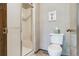 The bathroom features a toilet and glass-enclosed shower with neutral wall-paper and tile at 2783 W Long Dr # B, Littleton, CO 80120