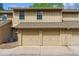 Tan townhome exterior showing two garage doors under a roof between the 2nd story windows at 2783 W Long Dr # B, Littleton, CO 80120