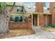 Inviting two-story townhome with a charming brick facade, lush landscaping and an entry walkway to the covered front entrance at 2783 W Long Dr # B, Littleton, CO 80120
