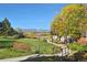 Beautiful view of common green space with a walking path, bridge, and mountain backdrop at 2783 W Long Dr # B, Littleton, CO 80120