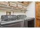 This laundry room features modern gray washing machine, dryer, shelves, and storage baskets at 2783 W Long Dr # B, Littleton, CO 80120