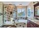 Luxurious bathroom featuring a soaking tub, glass shower, and granite countertops at 9602 S Hackberry St, Highlands Ranch, CO 80129