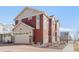 Exterior view of a two-story home featuring a two car garage and brick accents at 10152 Yampa Ct, Commerce City, CO 80022