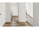 Hallway featuring wood-look flooring and a view of the laundry room with modern appliances at 10152 Yampa Ct, Commerce City, CO 80022