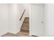 Staircase featuring wooden steps, white walls, and a white door at the bottom at 10152 Yampa Ct, Commerce City, CO 80022