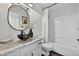 Bathroom with modern black sink, round mirror, and shower/tub combination at 5323 E Hamilton Ave, Castle Rock, CO 80104