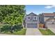 Beautiful two-story home with gray siding, stone accents, and a lush, green front yard at 5323 E Hamilton Ave, Castle Rock, CO 80104