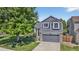 Beautiful two-story home with gray siding, stone accents, and a lush, green front yard at 5323 E Hamilton Ave, Castle Rock, CO 80104