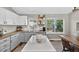 Bright kitchen featuring white cabinets, wood countertops, and a large kitchen island with quartz countertop at 5323 E Hamilton Ave, Castle Rock, CO 80104