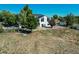 Aerial view of a fenced property with a home, sheds, and mature trees, providing a sense of privacy and space at 6242 W Lakeside Ct, Littleton, CO 80125