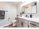 Bright bathroom features a dark framed mirror, white countertops, and gray cabinetry at 6242 W Lakeside Ct, Littleton, CO 80125