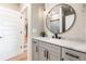 Bathroom features a marble countertop, a large round mirror, and gray cabinetry at 6242 W Lakeside Ct, Littleton, CO 80125