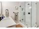 Bathroom featuring a frameless glass shower with marble wall tiles, black hardware, and a vanity at 6242 W Lakeside Ct, Littleton, CO 80125