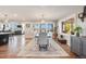 Elegant dining room with a rustic table, modern light fixture, and scenic views from the large windows at 6242 W Lakeside Ct, Littleton, CO 80125