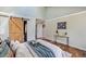 Bright bedroom featuring hardwood floors and a barn door entry to the bathroom at 9443 Palisade Ct, Highlands Ranch, CO 80130