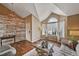 Bright living room featuring hardwood floors, vaulted ceiling, and a rustic accent wall at 9443 Palisade Ct, Highlands Ranch, CO 80130