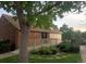 Charming brick home with a wooden deck, green lawn, and lush landscaping at 14282 E Radcliff Cir, Aurora, CO 80015