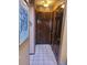 Hallway with tiled floor and three dark wood paneled doors at 14282 E Radcliff Cir, Aurora, CO 80015