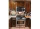 A view of the kitchen featuring stainless steel oven, microwave and wooden cabinets at 14282 E Radcliff Cir, Aurora, CO 80015