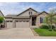 Inviting home featuring a three car garage, stone accents, and a well manicured lawn at 4767 S Odessa St, Centennial, CO 80015