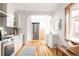 Well-lit kitchen showcasing stainless steel appliances, white cabinetry, and open layout with wood flooring at 2355 Forest St, Denver, CO 80207
