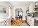 Bright kitchen featuring white cabinetry, stainless steel appliances, hardwood floors, and cozy breakfast nook at 2355 Forest St, Denver, CO 80207