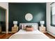 This primary bedroom has a large, bold wall with a round mirror, lamps, and woven night stands at 2355 Forest St, Denver, CO 80207