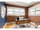 Home office with exposed brick, hardwood floors, and multiple windows at 2355 Forest St, Denver, CO 80207