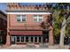 Exterior of The Cherry Tomato brick building with awning and decorative turrets against a blue sky at 2355 Forest St, Denver, CO 80207
