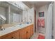 Well-lit bathroom featuring a light wood vanity, large mirror, and combined shower and bathtub at 4749 Old Post Ct, Boulder, CO 80301