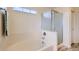 Bathroom featuring a tub and shower combo with a frosted glass door and a small window above at 5892 W 94Th Pl, Westminster, CO 80031