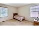 Simple bedroom with two windows, a striped bedspread, and neutral carpeting at 5892 W 94Th Pl, Westminster, CO 80031