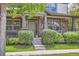 Inviting front porch with decorative pillars, brick accents, and well-maintained lawn and garden at 5892 W 94Th Pl, Westminster, CO 80031