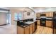 Well-lit kitchen with dark granite countertops, oak cabinets, black appliances and breakfast bar seating at 5892 W 94Th Pl, Westminster, CO 80031