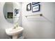 Charming powder room with pedestal sink, oval mirror, and textured walls at 23235 York Ave, Parker, CO 80138