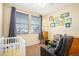 Comfortable Bedroom with crib, rocking chair, and plenty of natural light at 23235 York Ave, Parker, CO 80138