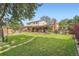 Expansive backyard featuring a large deck, patio, and lush green lawn at 10223 W 77Th Dr, Arvada, CO 80005