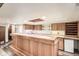Basement bar area with wood paneling, a built-in wine rack, countertop space, and a mini-refrigerator at 10223 W 77Th Dr, Arvada, CO 80005