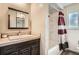 Cozy bathroom featuring a vanity with a sink, a mirror, and a shower with a patterned curtain at 10223 W 77Th Dr, Arvada, CO 80005