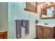 Bathroom featuring blue textured walls, wood vanity, and a modern mirror at 10223 W 77Th Dr, Arvada, CO 80005