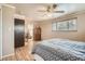 Spacious bedroom featuring hardwood floors, ceiling fan, natural light, and convenient en-suite bathroom at 10223 W 77Th Dr, Arvada, CO 80005