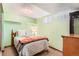 Guest bedroom featuring a comfortable bed with decorative pillows and blanket, and light green walls at 10223 W 77Th Dr, Arvada, CO 80005