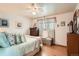 Bright bedroom featuring hardwood floors, ceiling fan, and a comfortable bed with pastel bedding at 10223 W 77Th Dr, Arvada, CO 80005
