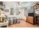 Cozy bedroom with wood floors, ceiling fan, and a comfortable bed with patterned bedding at 10223 W 77Th Dr, Arvada, CO 80005